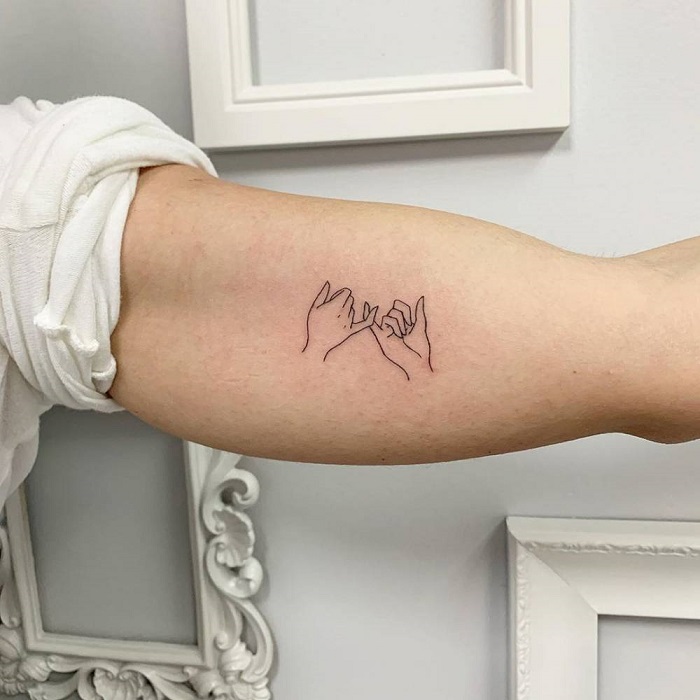 Pinky promise tattoo on the left inner forearm