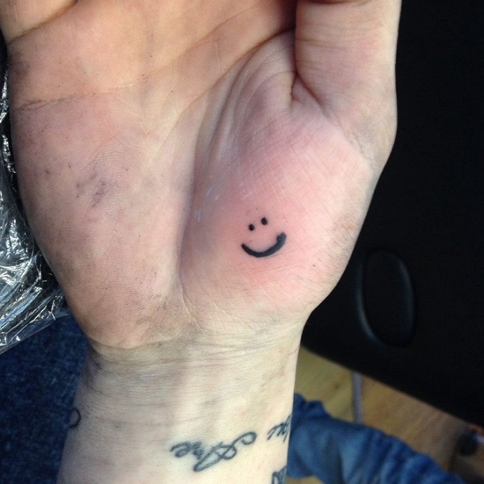 Midsection Of Woman Hand With Smiley Face Tattoo Stock Photo  Alamy