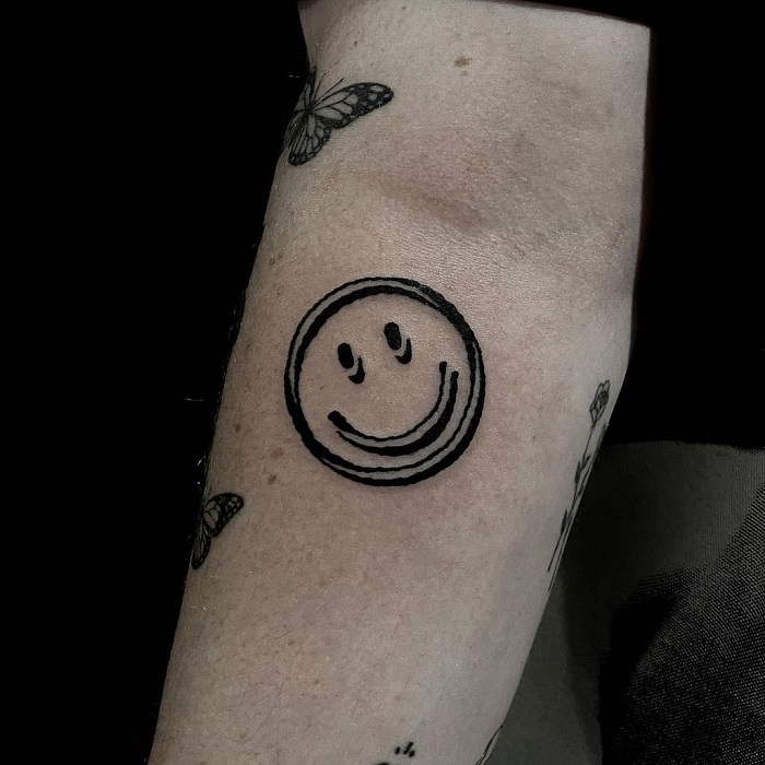 Minimalistic happysad face tattoo done on the finger